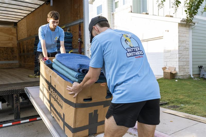 Butter Brothers crew loading a box of moving pads onto the truck