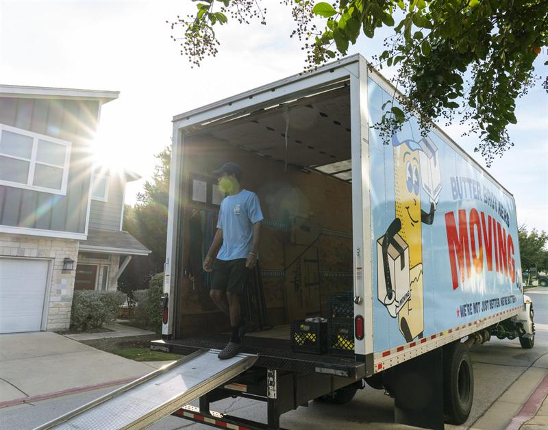 Butter Brothers mover stepping off the truck ramp next to the Butter Brothers truck